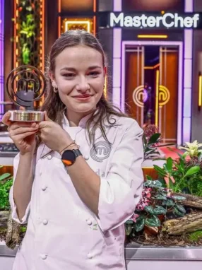 Ida Rojewska z trofeum MasterChef Nastolatki na tle kuchni programu